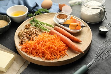 Different ingredients for making carrot cake on black table, closeup