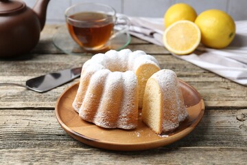 Delicious lemon cake with powdered sugar on wooden table, closeup