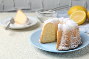 Delicious lemon cake with powdered sugar on light textured table, closeup
