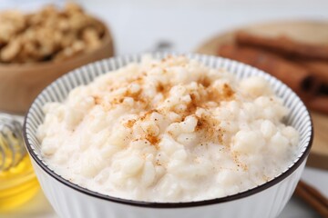 Tasty rice pudding with cinnamon on table, closeup