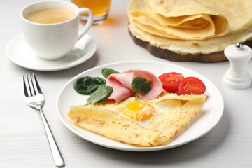 Delicious crepe with egg, ham and parmesan cheese served on white wooden table, closeup