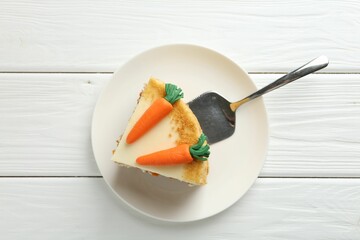 Piece of delicious homemade carrot cake and server on white wooden table, top view