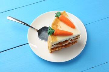 Piece of delicious homemade carrot cake and server on light blue wooden table