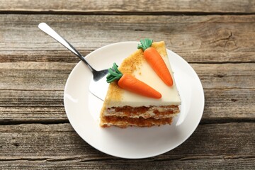Piece of delicious homemade carrot cake and server on wooden table