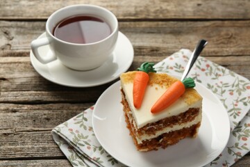 Piece of delicious homemade carrot cake served on wooden table