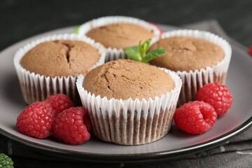 Delicious muffins with raspberries and mint on table, closeup