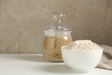 Brown rice and flour on white table. Space for text