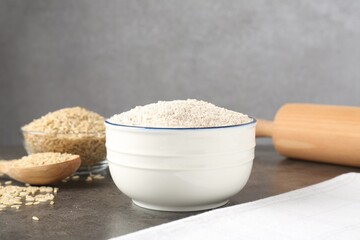 Brown rice and flour on grey table. Space for text