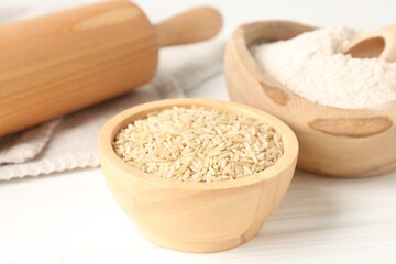 Brown rice and flour on white table, closeup