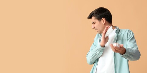 Young man rejecting garlic on beige background with space for text. Food allergy
