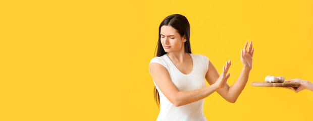 Young woman with food allergy on color background