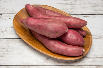 木のお皿に乗った不揃いなサツマイモ