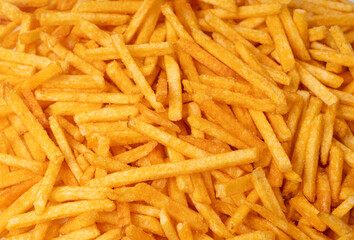 Fried chips sticks texture background, finger potato ketchup flavored chips pattern, shoestring fries