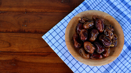 Dates fruit served on wooden plate with blue white napkin