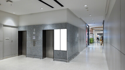 Obraz premium elevator entrance with modern architecture, empty lobby with metal lift doors and blank advertisement screen, contemporary office or commercial building interior design with clean lighting