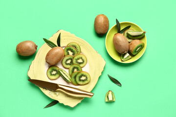 Plate and bowl with fresh kiwi on green background