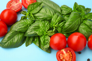 Fresh basil and cherry tomatoes on blue background