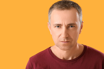 Obraz premium Portrait of serious mature man on orange background