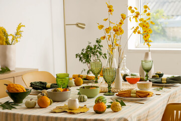 Autumn table setting with flowers, leaves and pumpkins