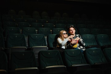Couples enjoy a private moment in a nearly empty movie theater