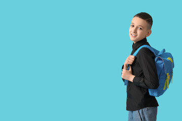 Cute schoolboy with backpack on blue background