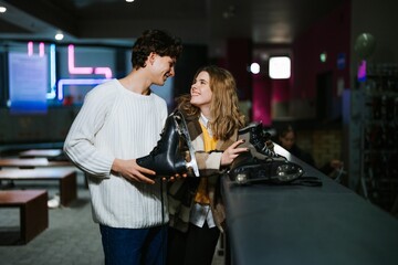 Young couple enjoying a fun day at the indoor ice skating rink together