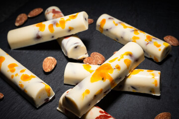 white chocolate bars with salted almonds, on dark background