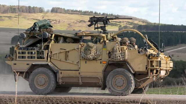 British army Supacat Jackal 4x4 rapid assault, fire support and reconnaissance vehicle moving at speed along a dusty dirt track