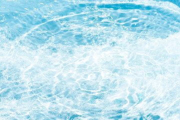 Blue water with ripples on the surface. Defocus blurred transparent blue colored clear calm water surface texture with splashes and bubbles. Water waves with shining pattern texture background.