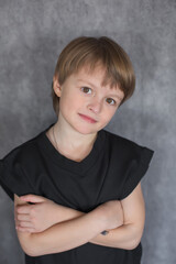 Portrait of a handsome blond boy with big brown eyes wearing a black sweatshirt