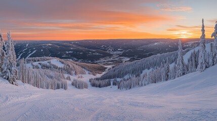 Naklejka premium Panoramic sunrise over snow-covered mountain slopes and valley.
