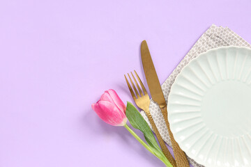 Table setting with tulip on lilac background. Mother's day concept