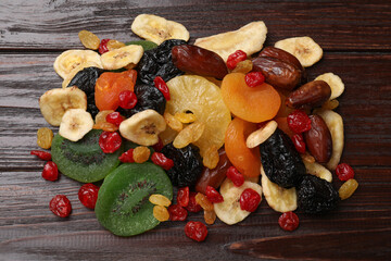 Mix of different dried fruits on wooden table, top view