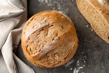 Whole and cut fresh bread on grey table, top view