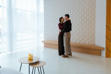 Couple dancing intimately in modern indoor space during daylight hours