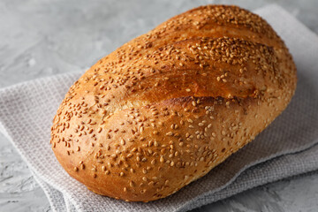 Freshly baked bread with seeds on grey table, closeup