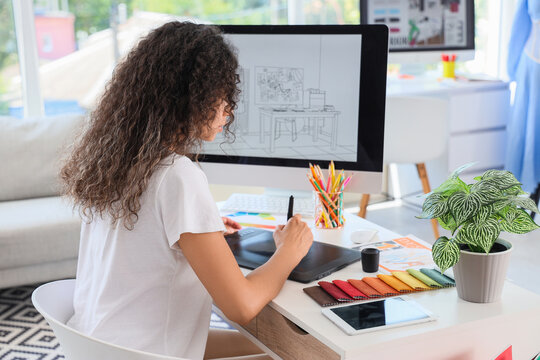 Female graphic designer working with tablet at table in office