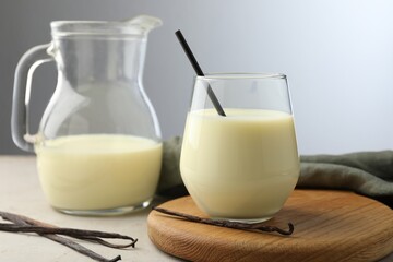 Delicious vanilla milk and pods on grey table