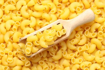 Raw horns pasta and scoop as background, top view