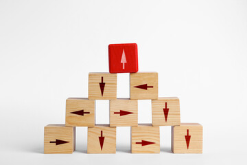 Obraz premium Wooden cubes with arrows pointing in different directions on white background