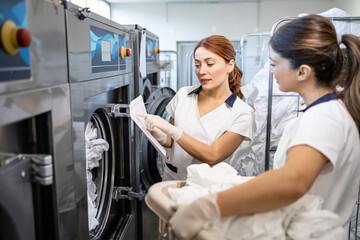 Female employees working together in laundry dry cleaning service.