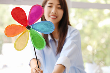 Young woman with toy windmill at home, closeup