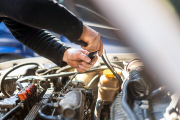 Obraz premium Auto mechanic working on car engine in his mechanic garage. Repair service. close up