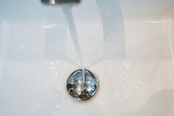 Running Tap Water into Clean Sink Drain – Hygiene Concept