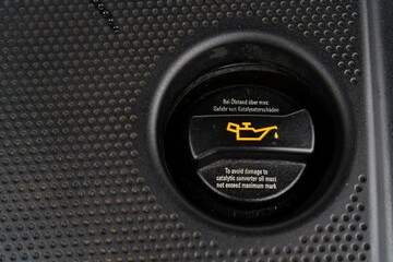 Engine Oil Cap with Warning Icon and Text on Car Engine Cover
