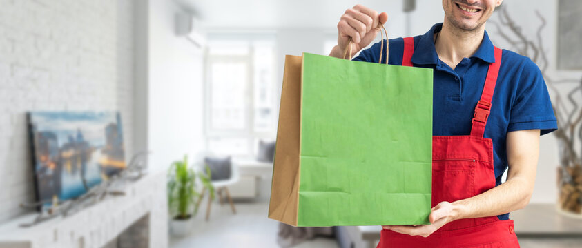 Diverse of paper containers for takeaway food. Delivery man is carrying pizza