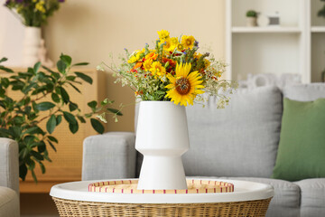 Wild flowers in vase on coffee table in interior of living room. Closeup