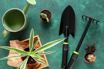 Gardening supplies with shovel, rake and watering can on green grunge background. Top view