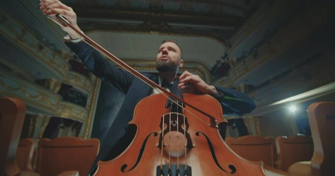 A solo cellist in a beautifully restored historic theatre performing a timeless masterpiece