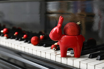 Porcelain deer on piano keyboard and Christmas decorations. Closeup